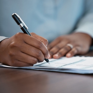 Close up of a hand signing legal documents